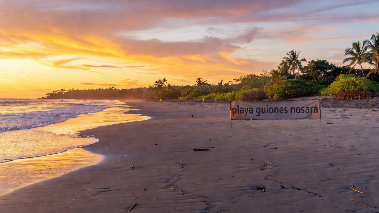Long empty stretch of Playa Guiones in Nosara at sunrise